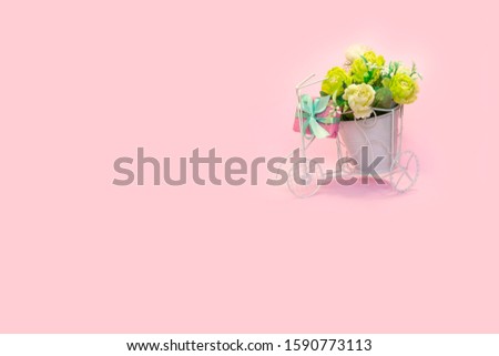 Retro bicycle with pot of bouquet flowers and gift boxes on pink background, copy space. Concept for Valentine's day, mother's day, wedding card and women's holiday