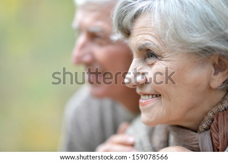 beautiful elderly couple on the background of autumn leaves