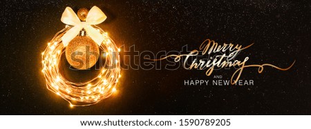 Christmas background. Glowing circle from a garland in the form of a Christmas toy on a black background with glitters. Festive Banner Lettering