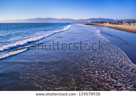 Foamy surf rolls in to the beach at Venice Beach, California.
