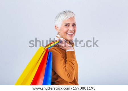 Mature attractive woman in enjoying a good shopping , with bags in hand. Senior happy summer shopping woman with shopping bags isolated on white background