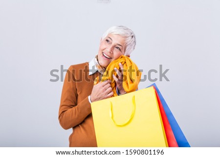 Happy mature good looking woman happy with her purchase, holding new cardigan against her face and smiling. Shopping concept