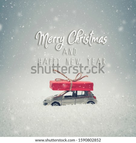 Merry Christmas and Happy New Year card. Christmas gift box on toy car with snow. Snow effect added.