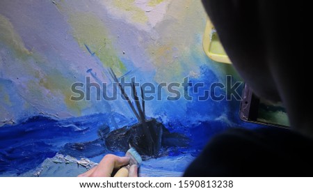 Artist copyist paint seascape with ship in ocean. Craftsman decorator draw as boat sail on blue sea with acrylic oil color. Draw finger, brush, knife palette. In hand of cellphone tablet computer pc.