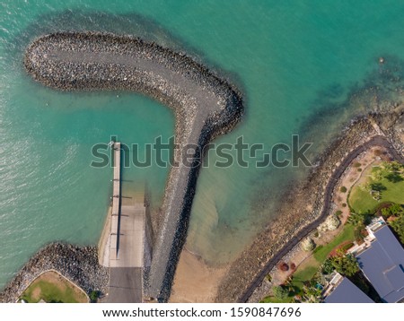 Airlie beach waterfront TOP DOWN aerial view. Dramatic DRONE view from above. Abstract. Rock formations with marina yachts in ocean. Shot in Whitsundays Islands, Queenstown, Australia.