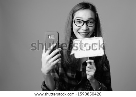 Portrait of young beautiful Asian hipster woman in black and white