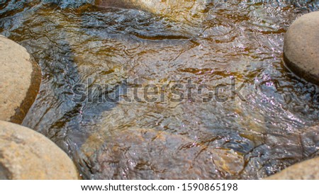 the surface of the water on the mountain river and the rocks on the bottom