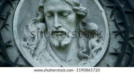 Jesus Christ antique statue against a background of gray stone. 