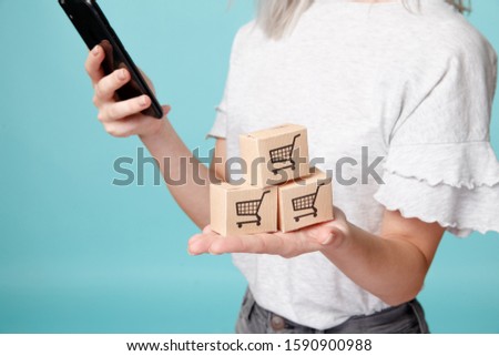 Female with phone and picture of shopping bascket. Shopping online concept.