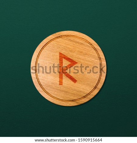Wooden board with the image of the Scandinavian rune on a green background.