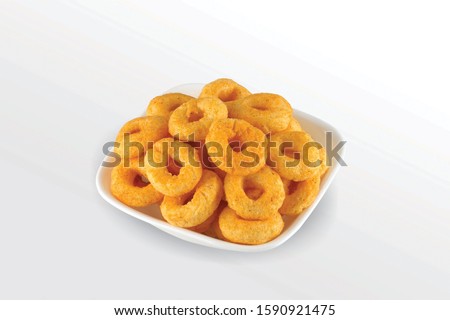 Pile of crispy Corn ring, Cream & Onion snack (Fryums - Frymus) in white dish isolated on white background, Sweet brekfast cereal rings - Image Royalty-Free Stock Photo #1590921475