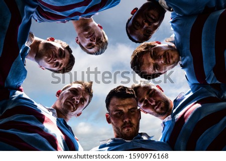 Rugby players against blue sky with clouds