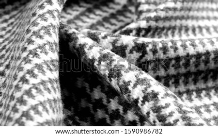 Background texture, pattern. The fabric is thick, warm with a checkered pattern, gray black. 