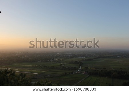 view of Mount Merapi, sunset, and green trees 
