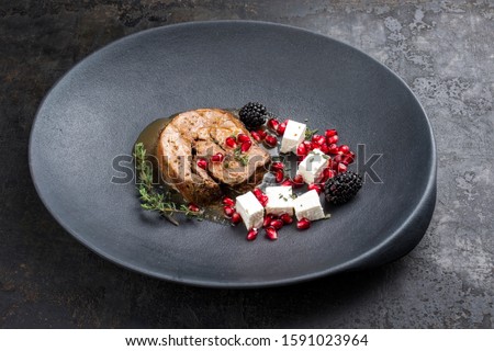 Gravy Greek lamb roast with feta cheese and fruits as minimalistic gourmet meal as closeup in a modern design plate with copy space 
