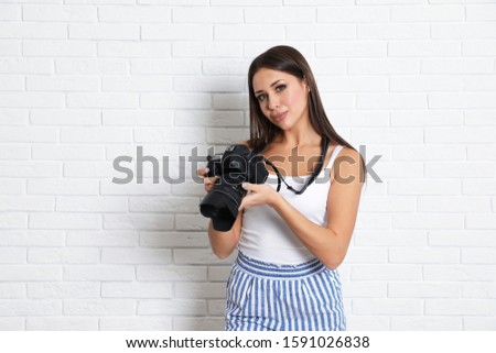 Professional photographer working near white brick wall in studio