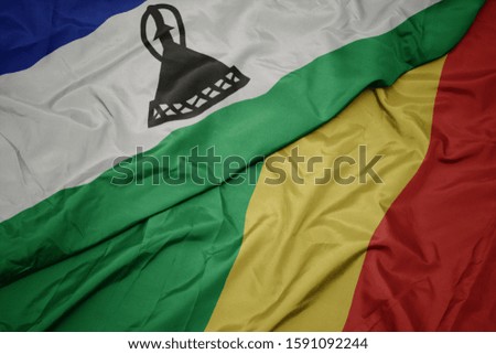 waving colorful flag of republic of the congo and national flag of lesotho. macro