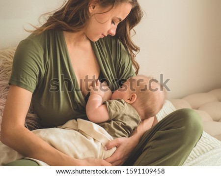 The concept of breastfeeding. Portrait of mom and breastfeeding baby.  Royalty-Free Stock Photo #1591109458