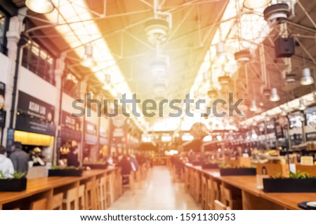 Blurred shot of big modern food hall or food court. Defocused background for design. Sunny toned photo Royalty-Free Stock Photo #1591130953