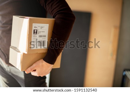 Young man carrying packages for shipment	