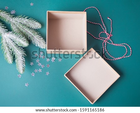 Opening and empty Christmas gift box on the green background with pine branch and Christmas decoration