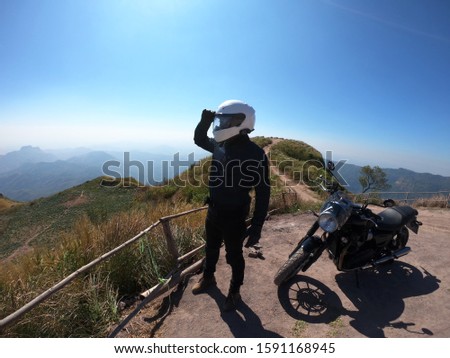 Biker happy journey and looking to the mountains scenery landscape background. Traveller by motorcycle at holiday. Biker relaxing in freedom lifestyle travel by motorbike.