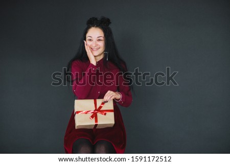 Christmas fashion photo of a nice woman holding a christmas gift