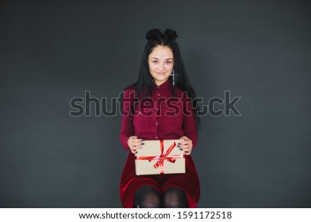 Christmas fashion photo of a nice woman holding a christmas gift