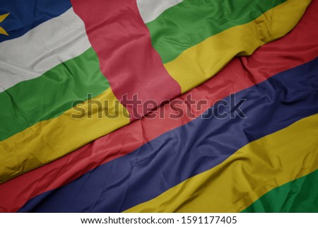 waving colorful flag of mauritius and national flag of central african republic. macro