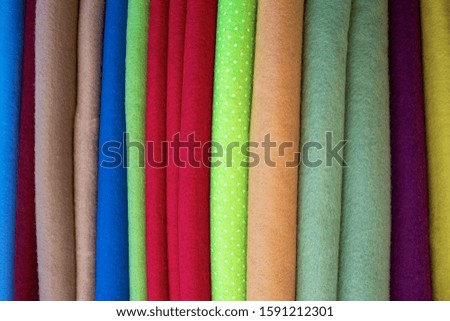 Many different colored pieces of fabric and textiles in a factory shop or store or bazar.