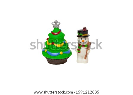 Children's toy - A snowman in a hat stands next to a Christmas tree decorated with Christmas toys on a white isolated background
