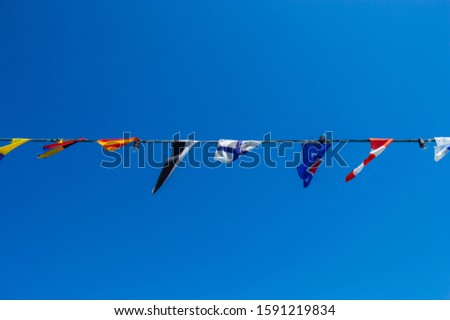 Rope with the flags of different countries on a background of blue sky in detail