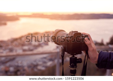 A Camera on tripod  is photographing  beautiful view at twilight 
