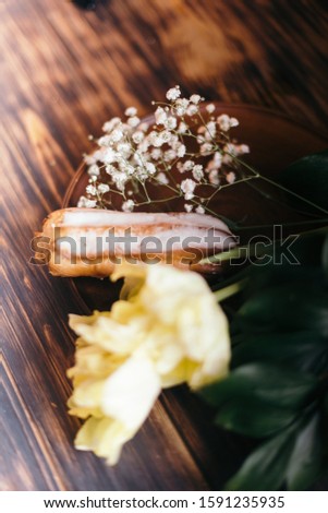 Choux cake on a wooden background with tulips.