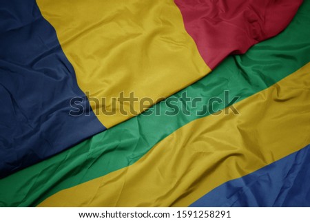 waving colorful flag of gabon and national flag of chad. macro