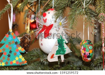 Christmas toys on the tree. Blurred colorful lights background.