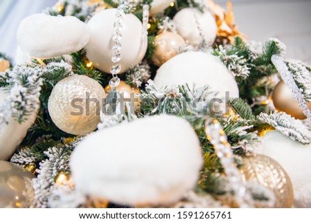 Christmas background golden flowers cones tree with branches of spruce, covered with white artificial snow and balls felt.