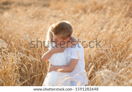 boy and girl hugging in wheat field