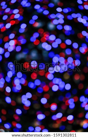 Beautiful saturated blurred multi-colored lights. The concept of the New Year background. Vertical.