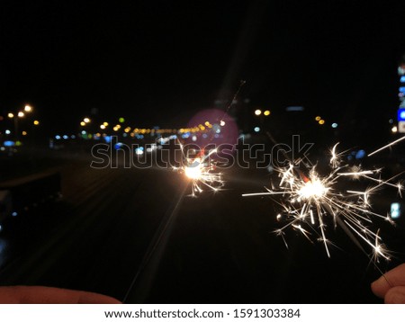 Happy New Year, Glittering burning sparkler against blurred bokeh light background