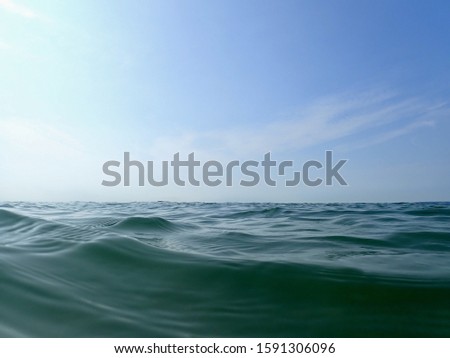 A closeup look of the sea waves under a blue sky and sunlight - a cool picture for backgrounds