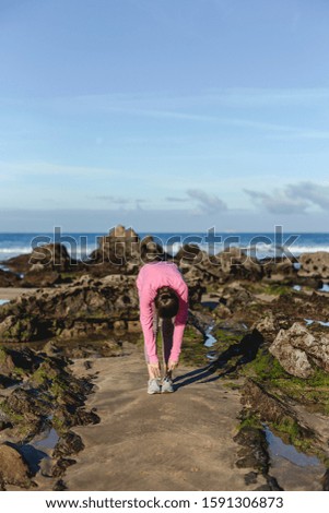 Beautiful Caucasian middle-aged brunette woman practicing yoga on the beach. Relax