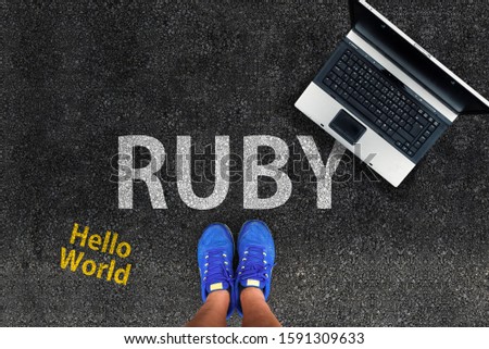 Ruby programming language. man legs in sneakers standing next to laptop and word Ruby