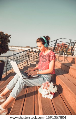 Attractive woman using laptop computer outdoors.