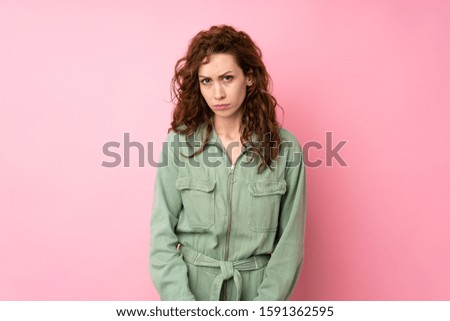 Young pretty woman over isolated pink background with sad and depressed expression