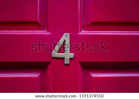 House number 4 on a lucky red door Royalty-Free Stock Photo #1591374550