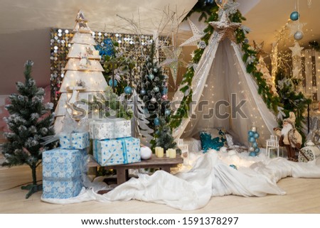 Christmas and New Year decorations with wigwam, fir tree, branches, bulbs, stars and warm garland lights. Winter, December holidays concept.