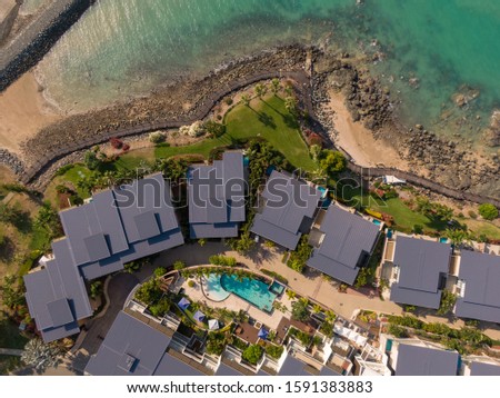 Airlie beach waterfront aerial view. Dramatic DRONE view of buildings from above. Waterfront properties & sea water. Mountain landscape background. Shot in Whitsundays Islands, Queenstown, Australia.