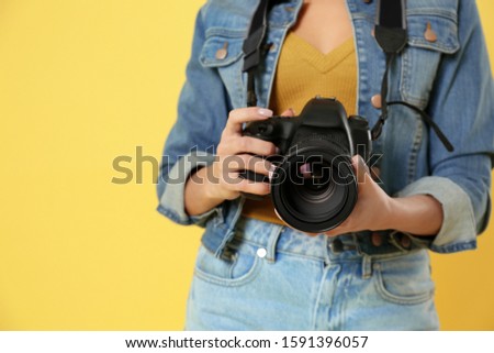 Professional photographer working on yellow background in studio, closeup