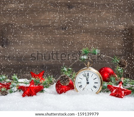 vintage christmas decoration red stars and antique golden clock in snow over wooden background
